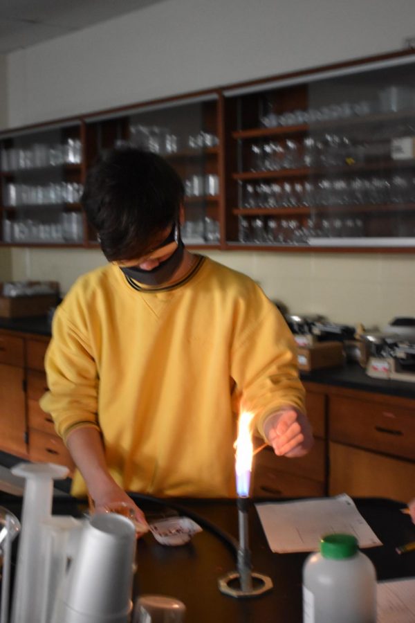Andrew Ross participates in chemistry flame lab.