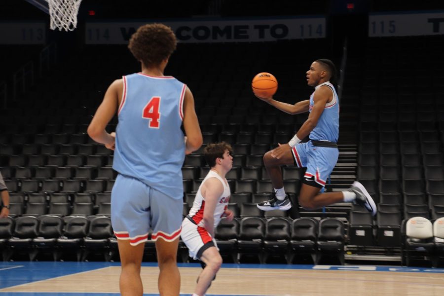 On the court at Paycom Center, senior Aaron Hall goes in for a layup against a Farmington defender during the final minutes of the game. The team traveled to Oklahoma City for a non-conference matchup, then stayed for the OKC Thunder professional basketball game. 