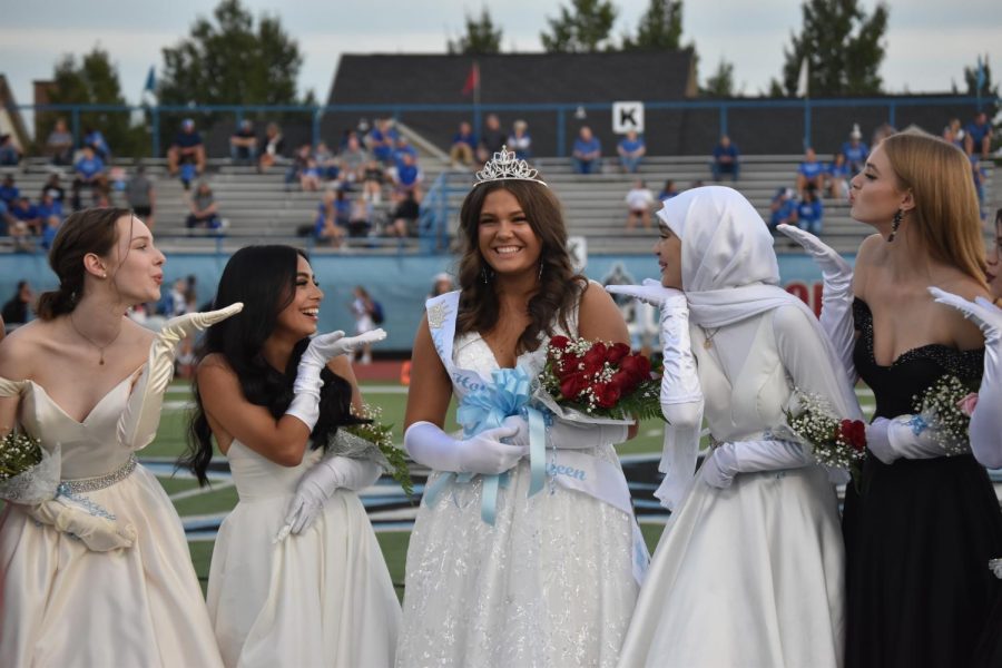 Maids surround newly crowned queen Abigail Holycross as professional photos are taken on the field.