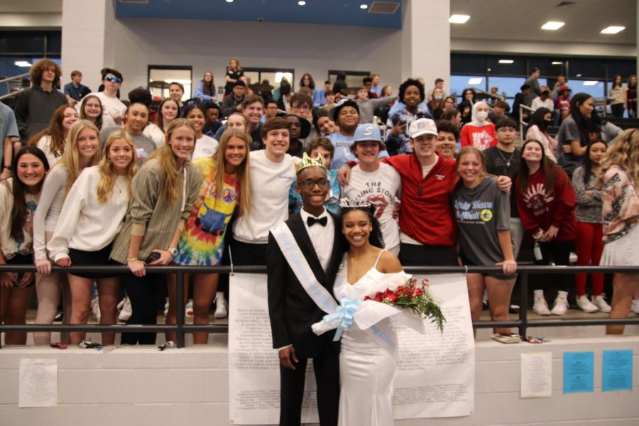 Newly crowned king and queen, Kelvin and Essynce pose in front of the student section.