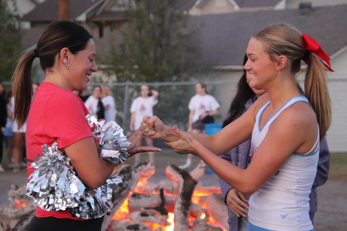 Senior cheerleader Grace Merle beats senior Belle Allie Nobel in the rock, paper, scissors competition at the Burn the Bears Bonfire.