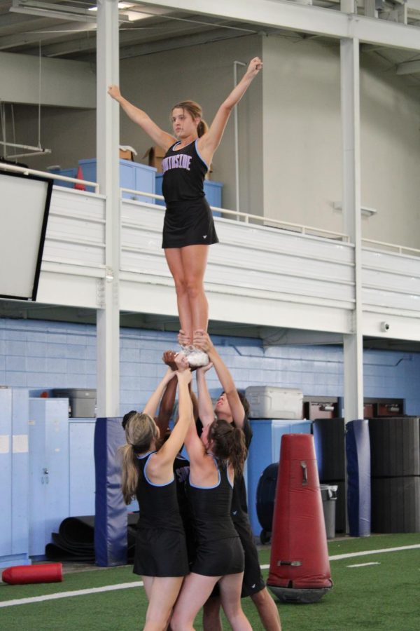 Cheer team practices for football game performance.