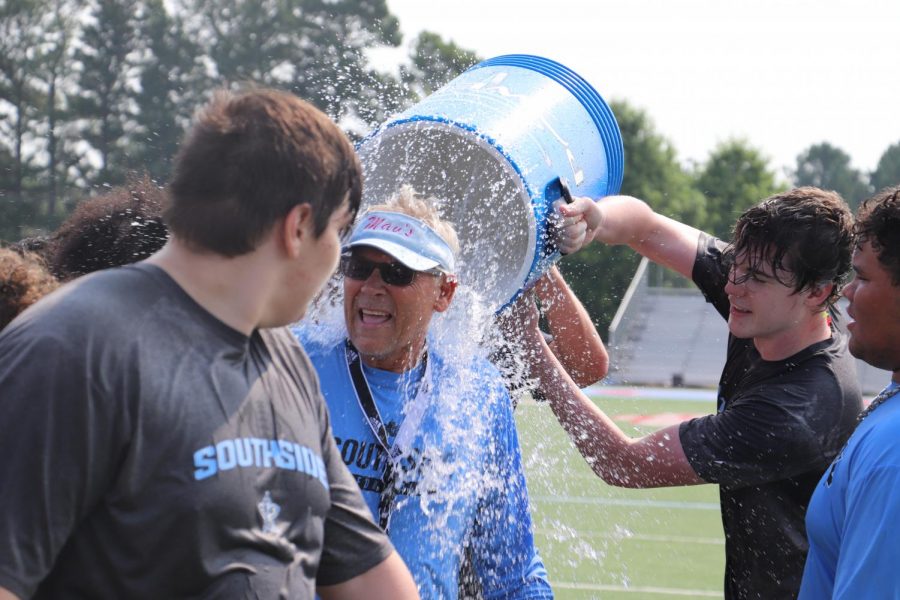 Summer practice ends with coach Kim Dameron receiving a splash of water from senior A.C. Woodard.