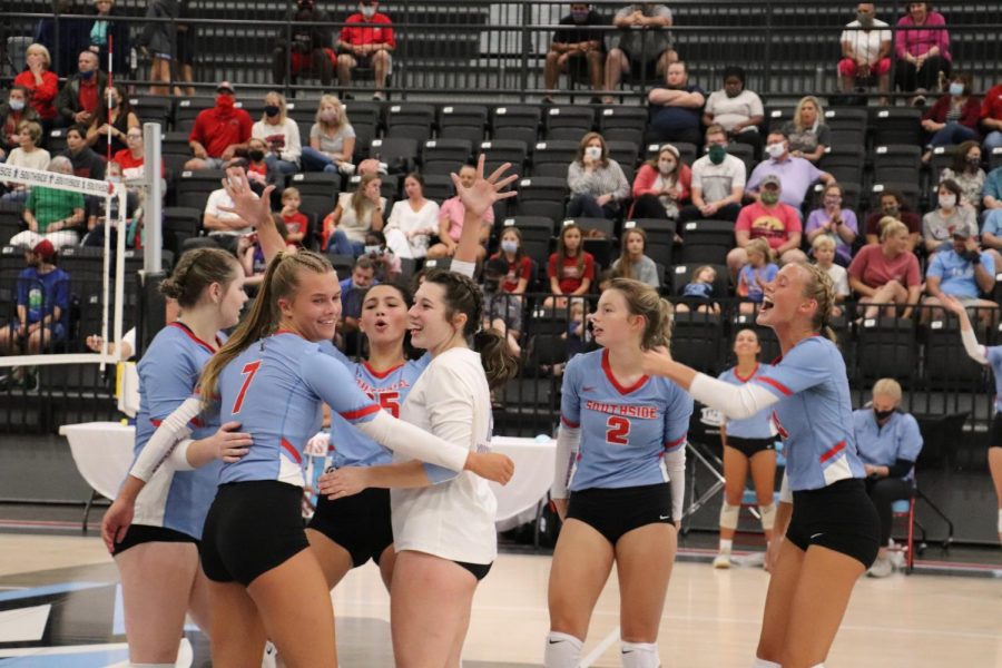 Celebrating a kill against Northside on Aug. 19, varsity teammates Olivia Melton and Gabby Dupree huddle midcourt during the third set.