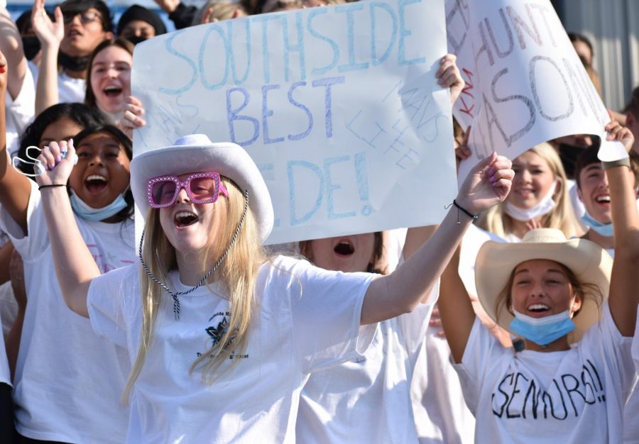 Dressed in her class color, senior Meg Norton cheers on the tricycle race during the Northside pep rally on Aug. 26.
